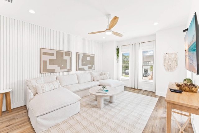 living room featuring light hardwood / wood-style flooring and ceiling fan