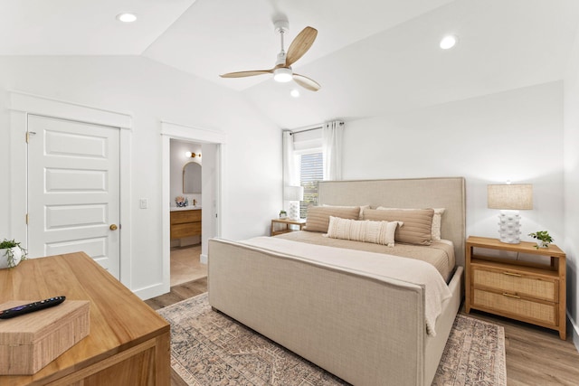 bedroom with light hardwood / wood-style flooring, ceiling fan, ensuite bath, and vaulted ceiling