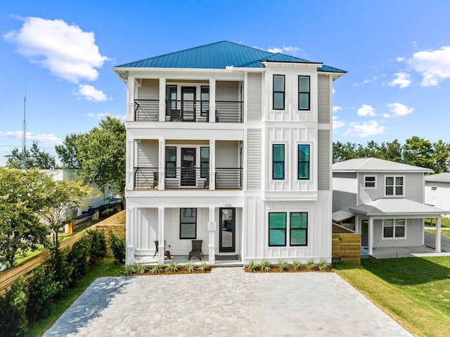 view of front of house featuring a front lawn, a balcony, and a porch