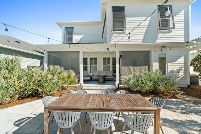 rear view of property featuring outdoor lounge area, central AC, a patio area, and a sunroom