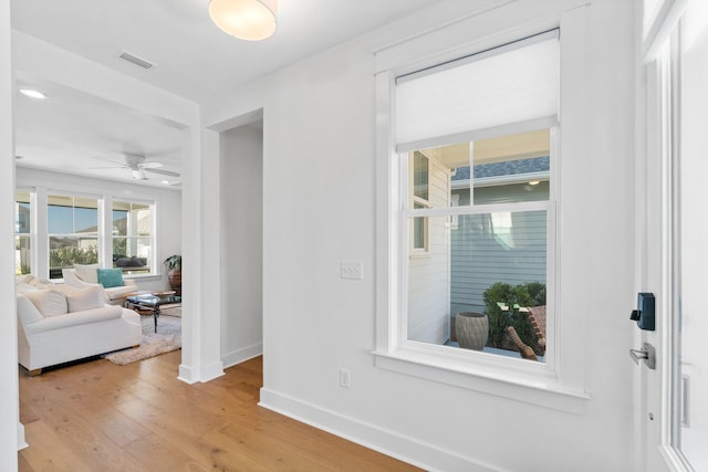 foyer with ceiling fan and light wood-type flooring