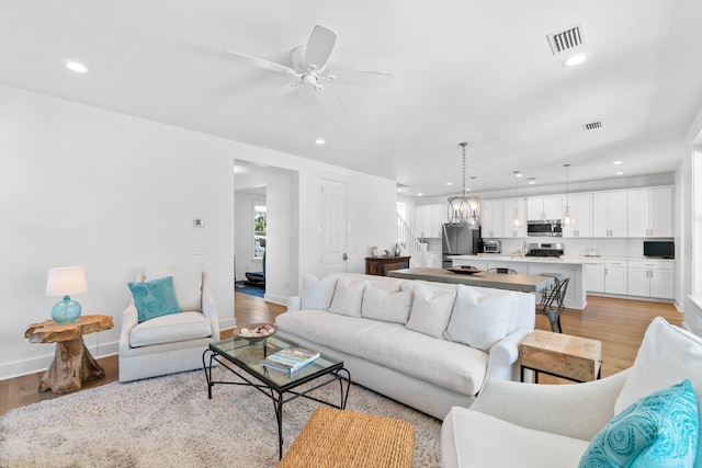 living room with ceiling fan and light wood-type flooring