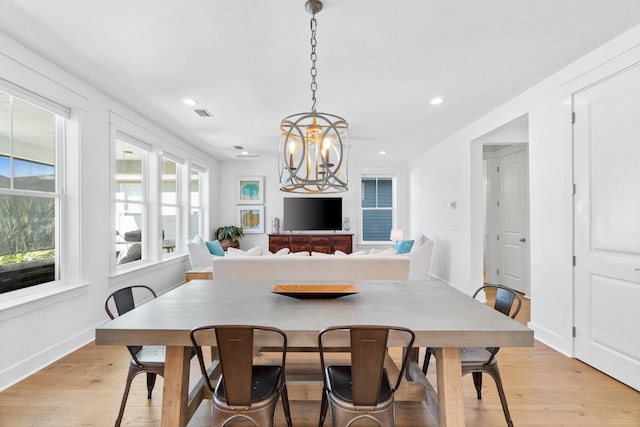 dining area featuring a notable chandelier and light wood-type flooring