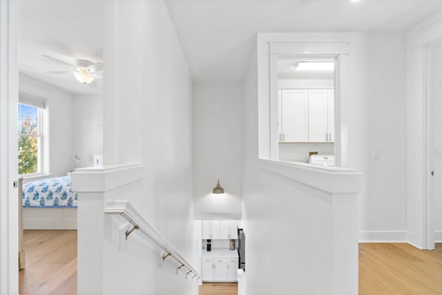 stairway with washer / dryer, ceiling fan, and hardwood / wood-style flooring