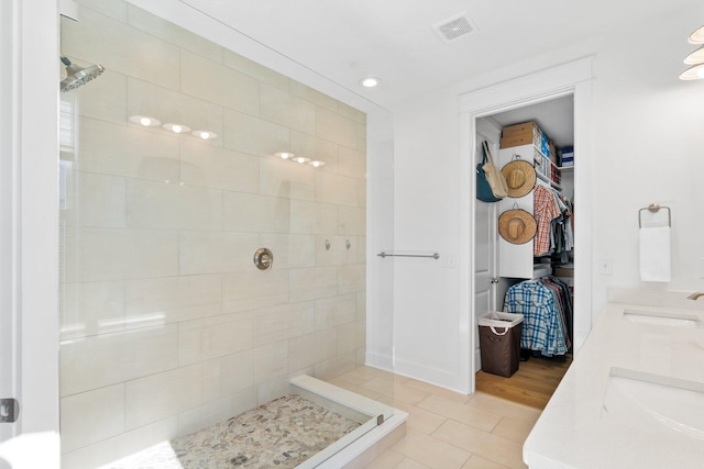 bathroom featuring tiled shower, vanity, and tile patterned floors