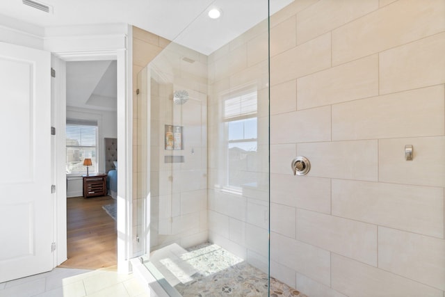 bathroom featuring tile patterned flooring and a tile shower