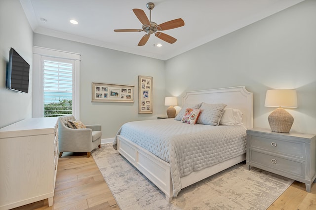 bedroom featuring light hardwood / wood-style floors, ornamental molding, and ceiling fan