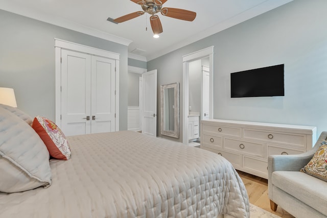 bedroom with ceiling fan, light wood-type flooring, a closet, crown molding, and ensuite bath