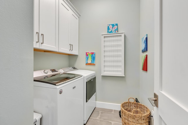 laundry area featuring cabinets, washing machine and dryer, and light tile patterned floors