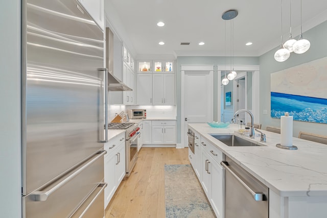 kitchen with a center island with sink, white cabinetry, decorative light fixtures, high quality appliances, and sink