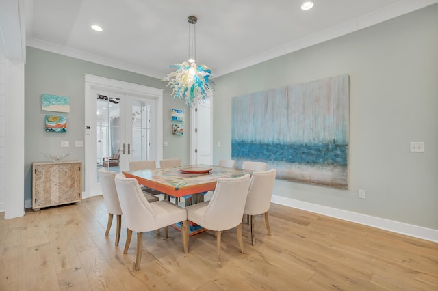 dining space with ornamental molding and light wood-type flooring