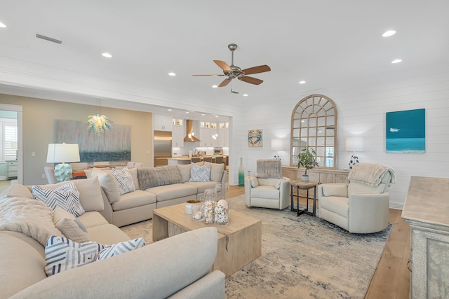 living room with light hardwood / wood-style floors and ceiling fan