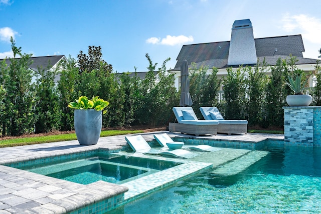 view of pool featuring an in ground hot tub