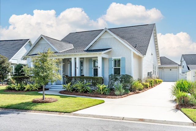 view of front of property with a porch, a front lawn, and a garage