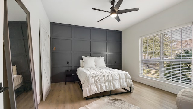 bedroom with light hardwood / wood-style floors, multiple windows, and ceiling fan