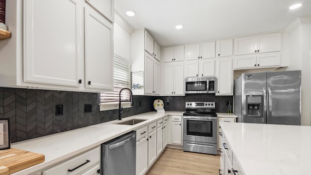 kitchen with white cabinetry, sink, and stainless steel appliances