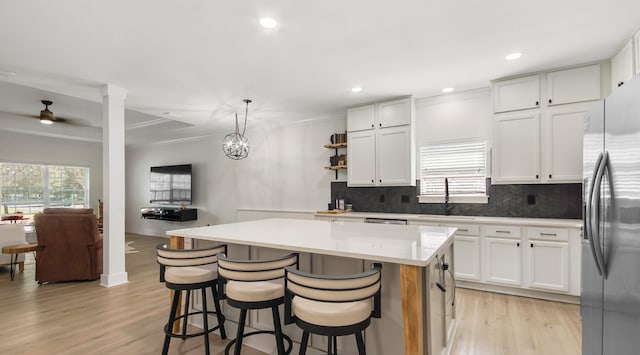 kitchen with white cabinets, stainless steel fridge with ice dispenser, and a center island