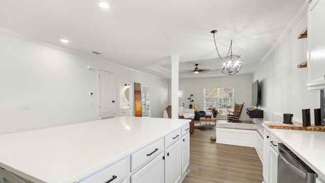 kitchen featuring hardwood / wood-style flooring, crown molding, white cabinets, pendant lighting, and dishwasher