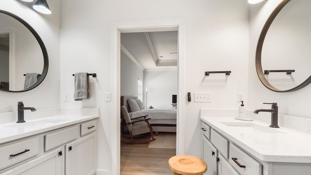 bathroom featuring wood-type flooring, crown molding, and vanity