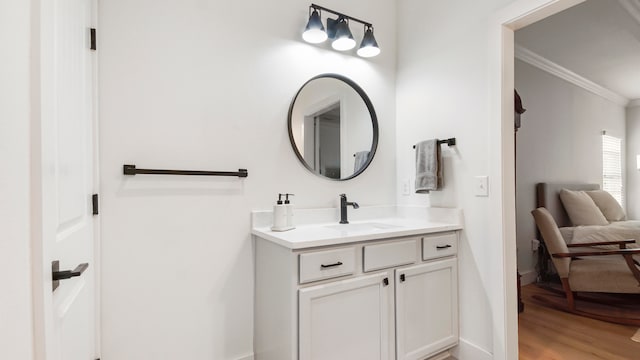 bathroom featuring wood-type flooring, crown molding, and vanity