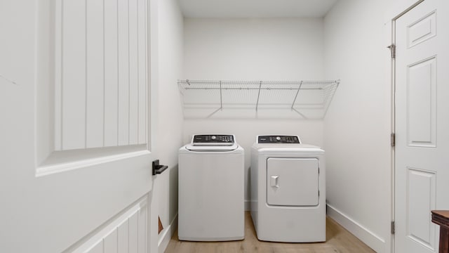 laundry area with light hardwood / wood-style flooring and independent washer and dryer