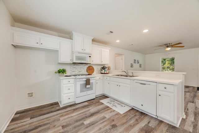 kitchen with white cabinets, light hardwood / wood-style flooring, and white appliances