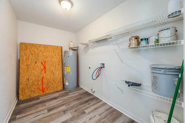 washroom featuring water heater, wood-type flooring, washer hookup, and electric dryer hookup