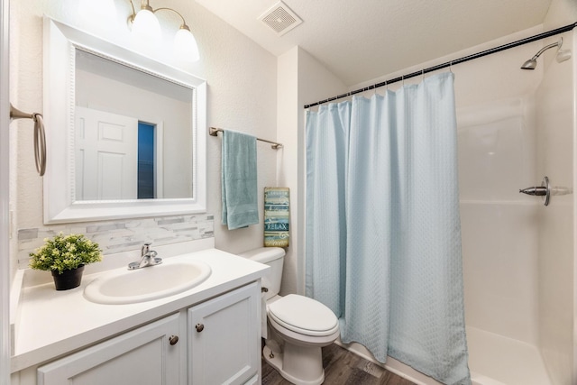 bathroom featuring a textured ceiling, a shower with shower curtain, hardwood / wood-style floors, toilet, and vanity