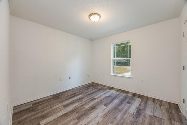 unfurnished room featuring a textured ceiling and wood-type flooring