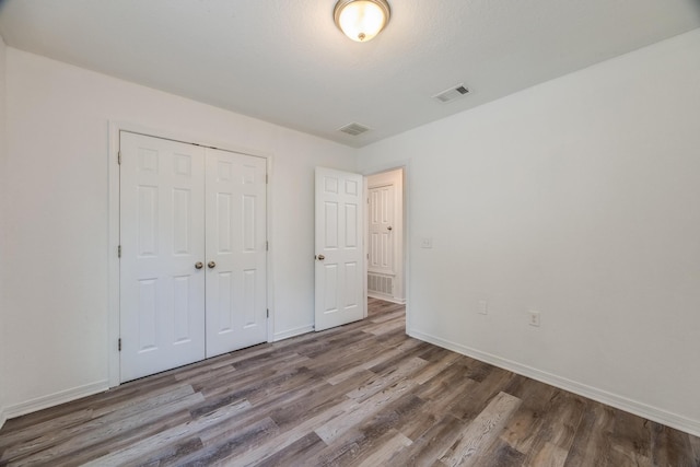 unfurnished bedroom featuring a closet and wood-type flooring