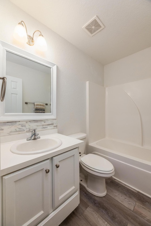 full bathroom featuring vanity, toilet, tub / shower combination, and hardwood / wood-style floors