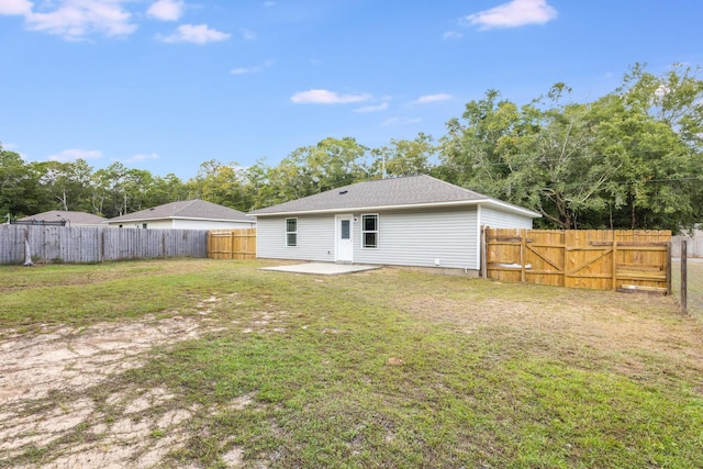 rear view of property featuring a patio and a yard