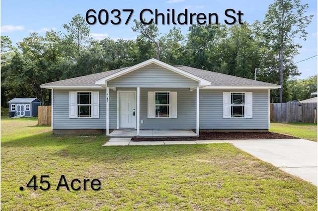 ranch-style house with a shed, a front yard, and a porch