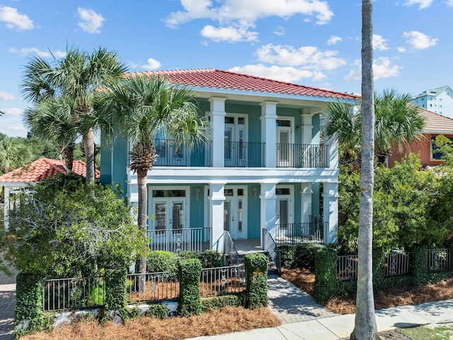 mediterranean / spanish home featuring covered porch and a balcony