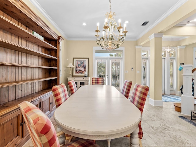 dining space featuring french doors, crown molding, and a chandelier