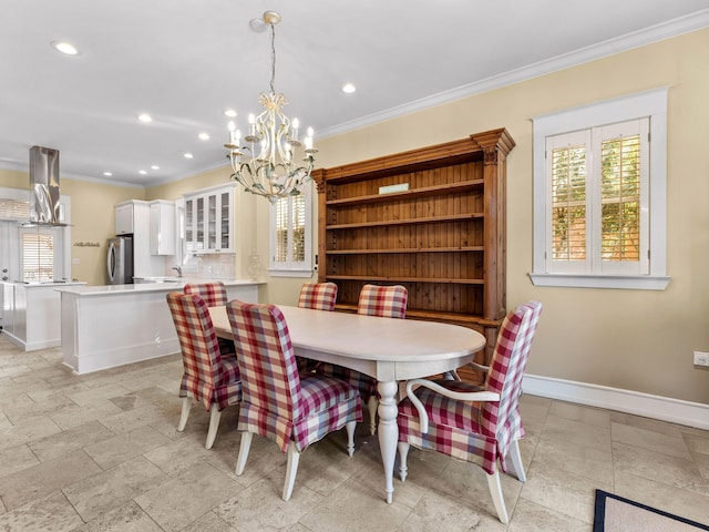 dining area with crown molding, sink, and a notable chandelier