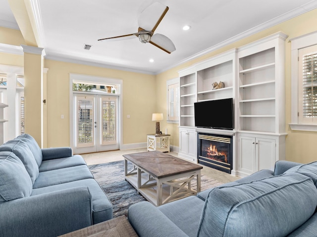 living room featuring decorative columns, french doors, ornamental molding, and ceiling fan