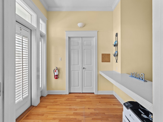 entryway with light hardwood / wood-style floors and ornamental molding