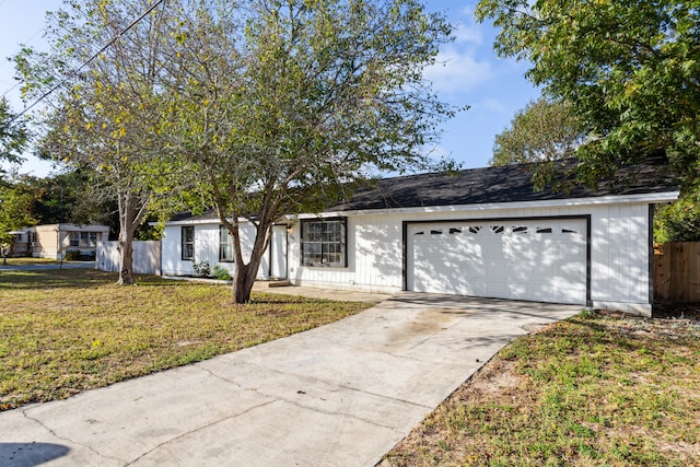 ranch-style house with a garage and a front lawn