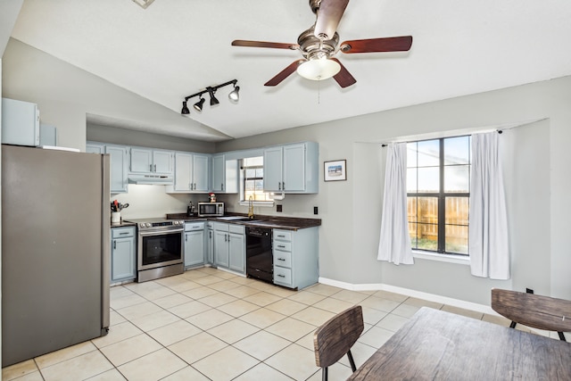 kitchen with sink, light tile patterned flooring, ceiling fan, stainless steel appliances, and lofted ceiling