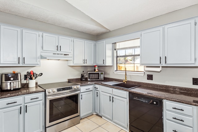 kitchen with appliances with stainless steel finishes, lofted ceiling, white cabinets, and sink