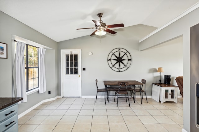 dining room featuring ceiling fan, light tile patterned flooring, and vaulted ceiling