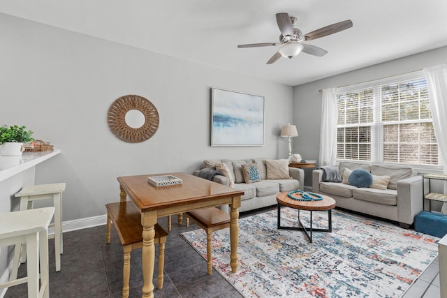 living area featuring ceiling fan, baseboards, and tile patterned floors