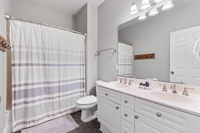 bathroom featuring tile patterned flooring, a sink, toilet, and double vanity