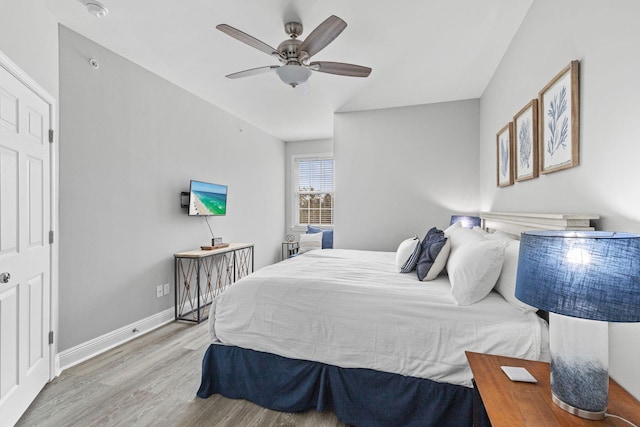 bedroom with ceiling fan, light wood finished floors, and baseboards