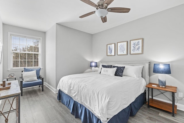 bedroom featuring a ceiling fan, baseboards, and wood finished floors