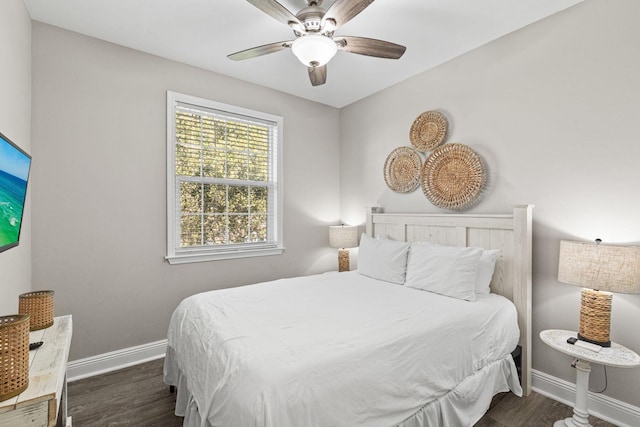 bedroom with a ceiling fan, baseboards, and dark wood-type flooring