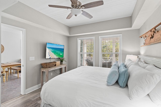 bedroom with ceiling fan, baseboards, and wood finished floors