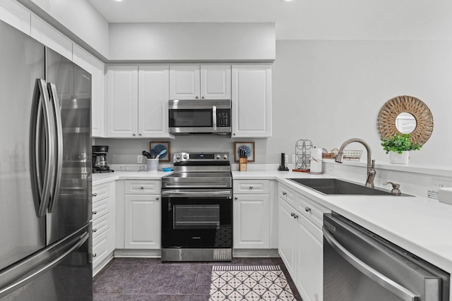 kitchen featuring stainless steel appliances, white cabinets, light countertops, and a sink