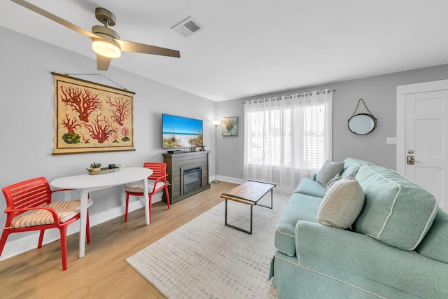 living room with light wood-type flooring and ceiling fan